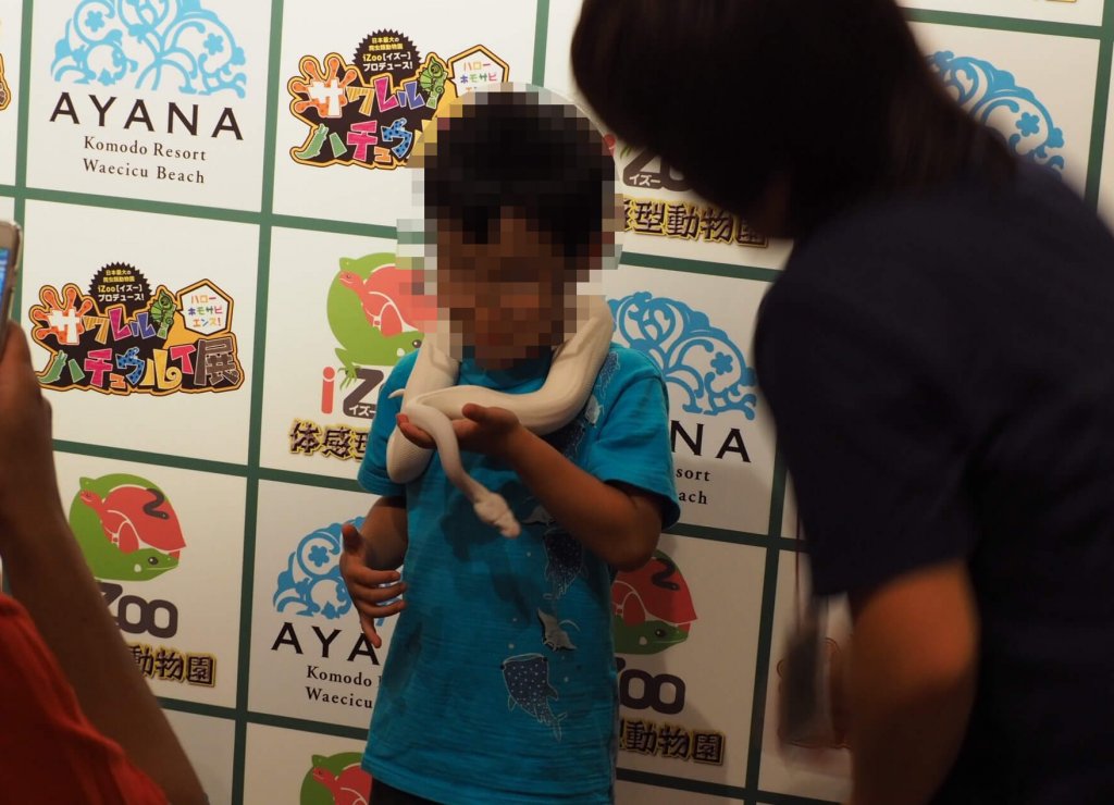 少年がヘビと記念撮影している様子